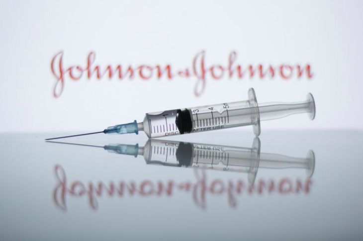 SPAIN - 2021/01/27: In this photo illustration a medical syringe seen displayed in front of the Johnson & Johnson logo. (Photo Illustration by Thiago Prudêncio/SOPA Images/LightRocket via Getty Images)