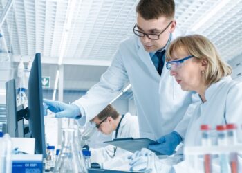 Two medical professionals conducting a round of research on new technologies. They're looking at a computer screen.