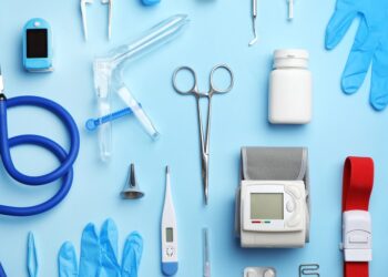 Medical supplies and devices arranged on a light blue background, including a stethoscope and blood pressure monitor.