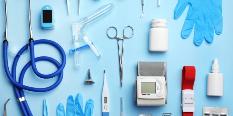 Medical supplies and devices arranged on a light blue background, including a stethoscope and blood pressure monitor.